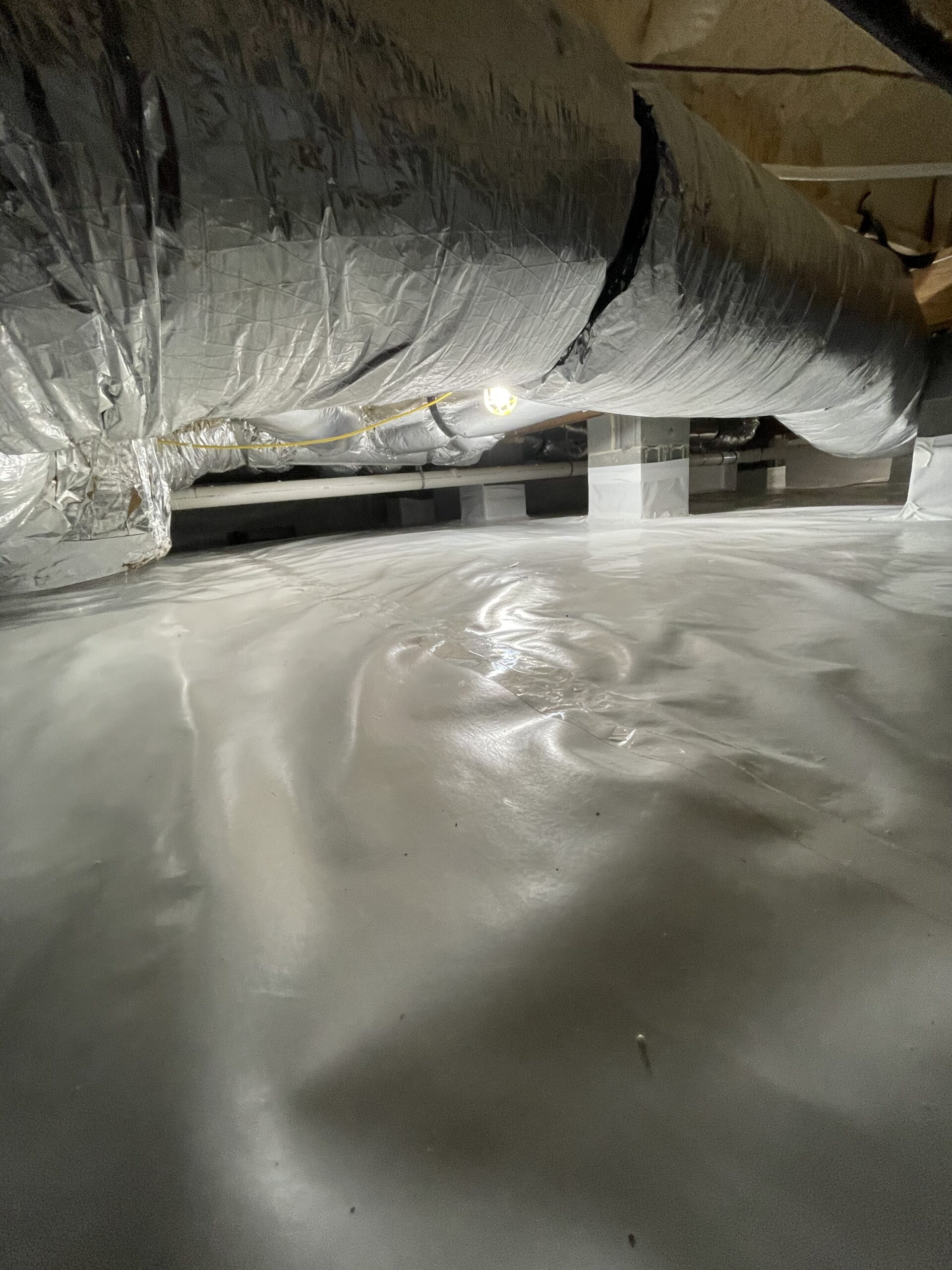 An encapsulated crawl space with ductwork running through.